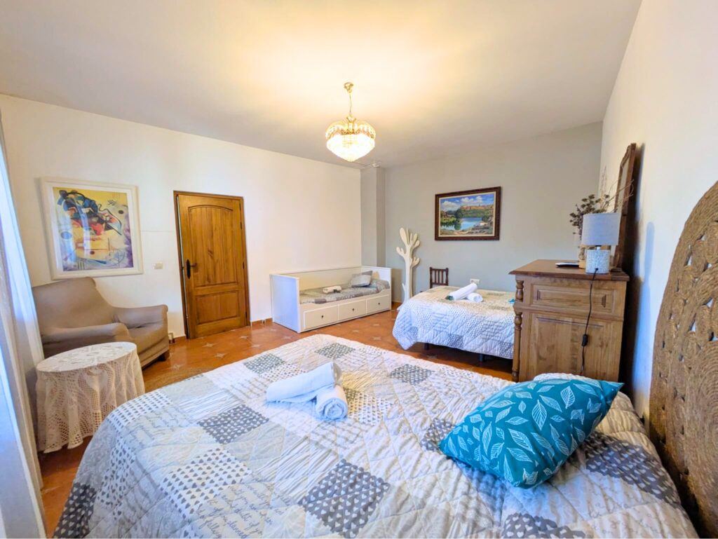 Habitación con tres camas y decoración acogedora.